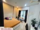 Cozy bedroom with a large orange bed, two chairs by the window, study desk, and potted plant