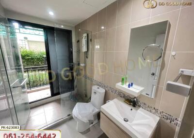 Modern bathroom with glass shower, vanity, and toilet.