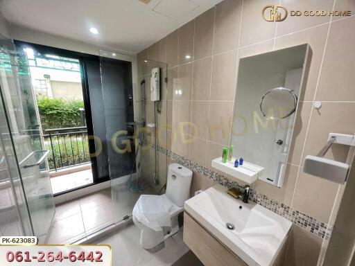 Modern bathroom with glass shower, vanity, and toilet.