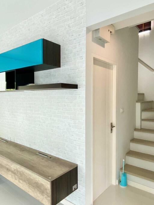 Modern hallway with floating shelves and staircase