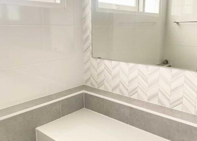 Modern bathroom with white countertop and large mirror