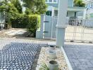 Front yard with a paved walkway and potted plants