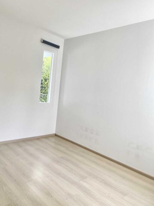 Empty bedroom with wooden flooring and a window