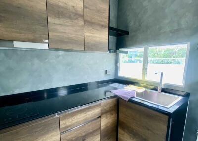 Modern kitchen with wooden cabinets and black countertop