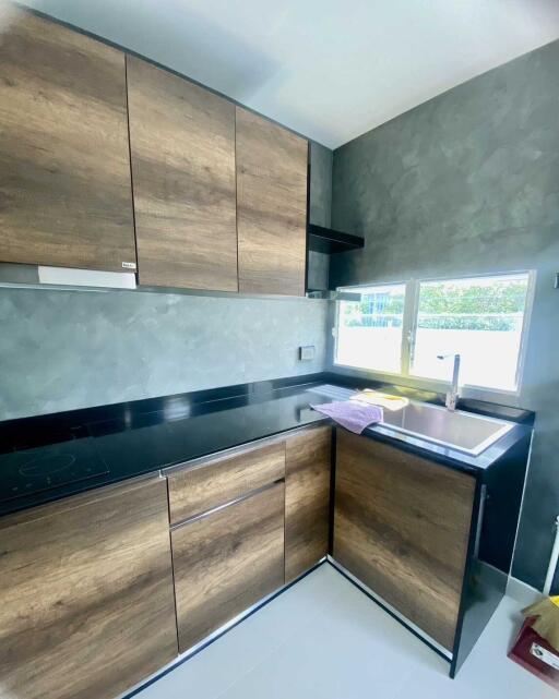 Modern kitchen with wooden cabinets and black countertop