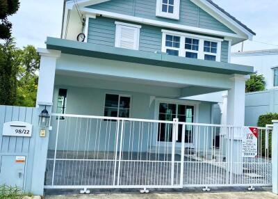 Two-story house exterior with gated driveway