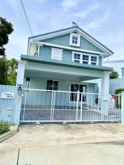 Two-story house exterior with gated driveway