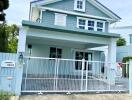 Two-story house exterior with gated driveway