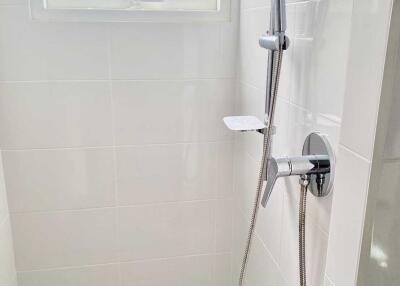 Modern bathroom shower with white tiles and showerhead