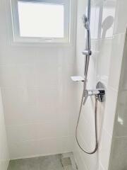 Modern bathroom shower with white tiles and showerhead