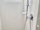 Modern bathroom shower with white tiles and showerhead