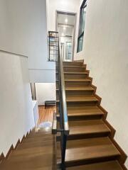 Stylish wooden staircase with modern railing in a bright hallway