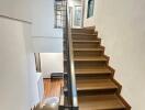 Stylish wooden staircase with modern railing in a bright hallway