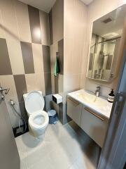 Modern bathroom view with sink, toilet, and tiled walls