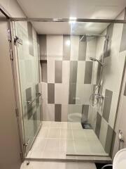 Modern bathroom with glass shower enclosure and tiled walls