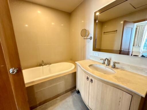 A modern bathroom with a bathtub and a vanity with a sink and mirror