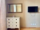 Bedroom with dresser, mirror, and mounted TV