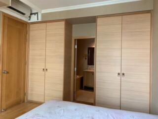 Bedroom with built-in wardrobes and view into the bathroom