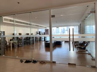 Spacious open-plan living room with glass doors and city view