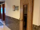 Hallway with wooden sauna door and tiled floor