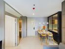 Modern dining area with a small table and chairs, adjacent to the kitchen