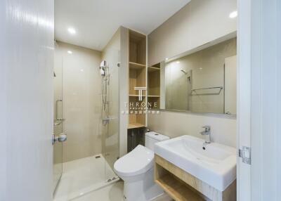 Modern bathroom with glass shower door, toilet, and sink