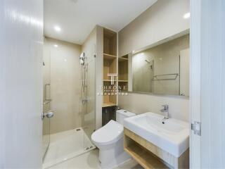 Modern bathroom with glass shower door, toilet, and sink