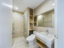 Modern bathroom with glass shower door, toilet, and sink