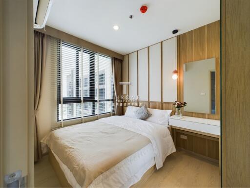 Modern bedroom with a large window, bed, and vanity table.