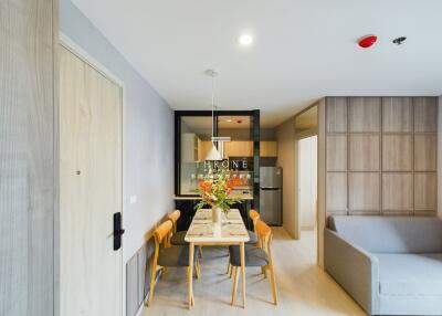 Modern dining space with table and chairs next to kitchen and living area