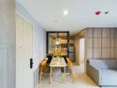 Modern dining space with table and chairs next to kitchen and living area