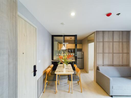 Modern dining space with table and chairs next to kitchen and living area