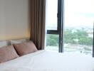 Modern bedroom with a large window and a view