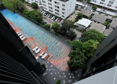 View of a building with a swimming pool and parking lot