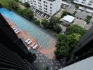 View of a building with a swimming pool and parking lot