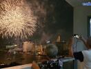 People watching fireworks from a balcony at night