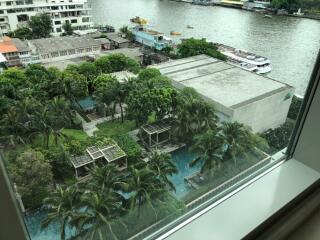 View from window overlooking pool, greenery, and river