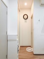 Minimalist hallway with wooden flooring and hat on wall hook