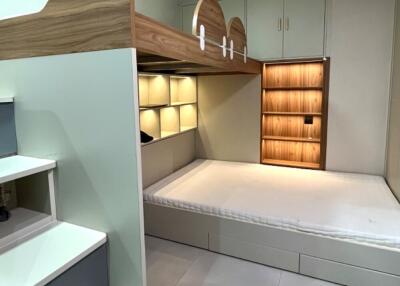 modern bedroom with lofted storage area and built-in shelving