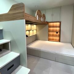 modern bedroom with lofted storage area and built-in shelving