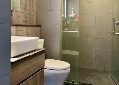 Modern bathroom with glass shower and wooden cabinet