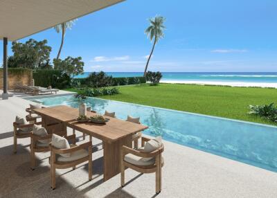 Luxurious beachside outdoor living space with dining table and infinity pool