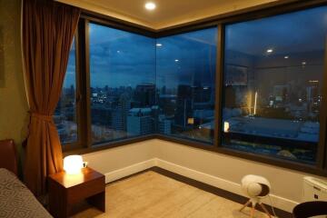 Bedroom with city view at dusk