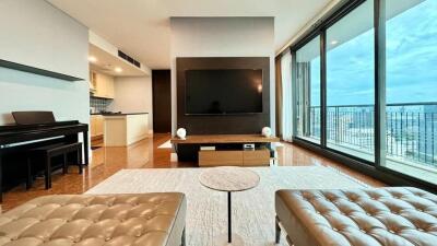 Modern living room with a large TV, piano, and a view of the city