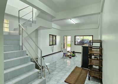 Spacious living area with staircase and tiled flooring