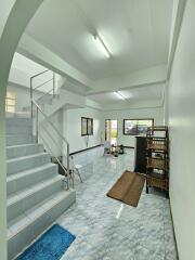 Spacious living area with staircase and tiled flooring