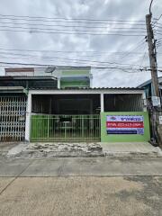 Front view of a residential building with a green gate and a 