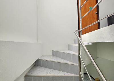 Indoor staircase with stainless steel railing and tile steps