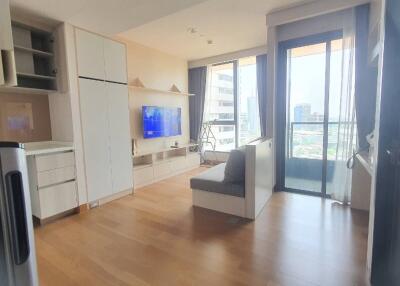 Modern living room with built-in shelves, TV, sofa, and large window with city view