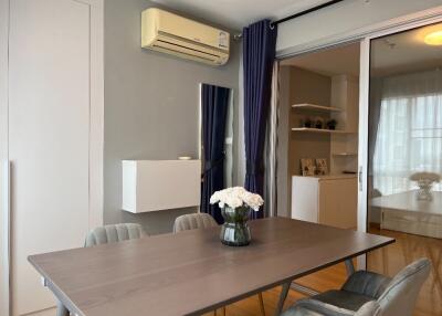 Modern dining area with table, air conditioner, and curtains